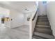 Open floor plan with a light gray floor that flows into a staircase with gray stairs at 1618 Meno Peak St, Las Vegas, NV 89115