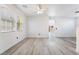 Bright living room featuring light gray floors, white walls, a ceiling fan and windows at 1618 Meno Peak St, Las Vegas, NV 89115