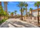 Long driveway leading to gated community lined with mature palm trees under a clear blue sky at 1840 Myrtle Island Dr, Las Vegas, NV 89117