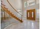 Bright foyer with a sweeping staircase, arched doorway and double doors, offering an elegant entry at 1840 Myrtle Island Dr, Las Vegas, NV 89117