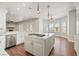 Open kitchen with white cabinets, marble counters, gas cooktop island, and stainless appliances at 1840 Myrtle Island Dr, Las Vegas, NV 89117