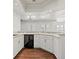Bright kitchen features a wine fridge, white cabinetry, wood floors, and modern countertops at 1840 Myrtle Island Dr, Las Vegas, NV 89117