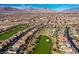 Aerial of a golf course community with beautiful homes and desert landscaping at 1994 Orchard Mist St, Las Vegas, NV 89135