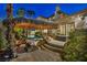 Outdoor kitchen near swimming pool featuring a built-in grill and a tiki hut for poolside entertaining at 1994 Orchard Mist St, Las Vegas, NV 89135
