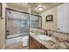 Bathroom with granite counters, framed mirror, and tiled shower with black trim at 1994 Orchard Mist St, Las Vegas, NV 89135