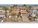 Beautiful two-story home with a red tile roof, mature landscaping, and a circular driveway at 1994 Orchard Mist St, Las Vegas, NV 89135