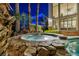 Relaxing hot tub with stone surround, palm trees, and a view of the modern home's exterior at 1994 Orchard Mist St, Las Vegas, NV 89135