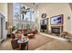 Cozy living room with a fireplace, large windows, and comfortable leather seating area at 1994 Orchard Mist St, Las Vegas, NV 89135