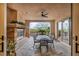 Charming covered patio with stone fireplace, ceiling fan, dining set, and views of the well-maintained backyard at 1994 Orchard Mist St, Las Vegas, NV 89135