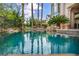 Inviting pool reflecting palm trees and the backyard's lush landscaping at 1994 Orchard Mist St, Las Vegas, NV 89135