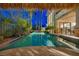 Beautiful pool with a tiki hut, tropical landscaping, and cascading waterfall for a tropical retreat at 1994 Orchard Mist St, Las Vegas, NV 89135