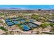Aerial view of multiple tennis courts in a community with well manicured grounds at 1994 Orchard Mist St, Las Vegas, NV 89135