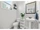 Stylish half-bathroom with wallpaper design, pedestal sink, and decorative mirror at 2127 Brewer Ave, North Las Vegas, NV 89081