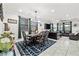 Open-concept dining and living area featuring a chandelier, decorative rug, and ample natural light at 2127 Brewer Ave, North Las Vegas, NV 89081