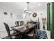 Formal dining room with chandelier and dark wood table; decorative wall art and rug at 2127 Brewer Ave, North Las Vegas, NV 89081