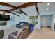 Comfortable living room with dark wood beams, stone fireplace, and backyard views at 2246 Almart Cir, Henderson, NV 89014
