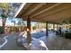 Expansive covered patio featuring lounge chairs, dining set, and a scenic backyard view at 2246 Almart Cir, Henderson, NV 89014