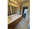 Bathroom boasts a double sink vanity with a large mirror and tile flooring at 228 Hiawatha Way, Mesquite, NV 89027