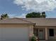 Charming home exterior featuring a tile roof, well-maintained garage door, and landscaped front yard at 228 Hiawatha Way, Mesquite, NV 89027