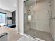Modern bathroom showcasing a glass-enclosed shower and a glimpse of a treadmill in the adjacent workout area at 253 Robledo St, Las Vegas, NV 89138