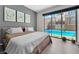 Relaxing bedroom view of a sparkling pool through a large sliding glass door, blending indoor and outdoor living at 253 Robledo St, Las Vegas, NV 89138
