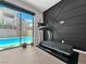 Bedroom showcases a modern treadmill against a textured wall, with a view of the pool through a large sliding glass door at 253 Robledo St, Las Vegas, NV 89138