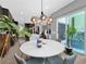 Sunlit dining area featuring a round table, stylish lighting, and views of the outdoor patio at 253 Robledo St, Las Vegas, NV 89138