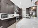 Modern kitchen featuring sleek, dark cabinetry, stainless steel appliances, and a stunning marble countertop island at 253 Robledo St, Las Vegas, NV 89138