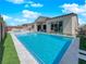 A sleek backyard pool and spa is complemented by artificial turf and a covered patio at 253 Robledo St, Las Vegas, NV 89138