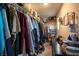 A walk-in closet with storage boxes, clothes hanging, and a mirror at 2678 Weathered Copper Ave, North Las Vegas, NV 89086