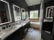 The updated bathroom features dual sinks with marble counters and a soaking tub near the window at 2747 Sandalwood Ave, Henderson, NV 89074
