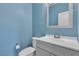 Clean bathroom with blue walls, a vanity with white countertops, and a toilet at 2832 Aragon Terrace Way, Henderson, NV 89044