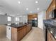 Spacious kitchen features stainless appliances, central island with sink, and seamless transition into the dining and living areas at 2832 Aragon Terrace Way, Henderson, NV 89044