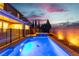 Inviting backyard pool and hot tub with an iron fence and exterior view of the home at dusk at 2832 Aragon Terrace Way, Henderson, NV 89044
