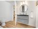 Modern bathroom with floating vanity, round mirror, and access to main bedroom at 3007 La Mesa Dr, Henderson, NV 89014