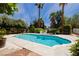 In-ground swimming pool surrounded by lush landscaping and a sunny sky at 3007 La Mesa Dr, Henderson, NV 89014