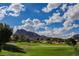Picturesque golf course view with manicured green grass, mountains, and a vibrant blue sky dotted with fluffy clouds at 3116 Richland Dr, Las Vegas, NV 89134