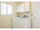 Bright laundry room showcases a white washer and dryer with upper cabinets at 3116 Richland Dr, Las Vegas, NV 89134