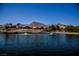 Waterfront homes with landscaping along a pond; mountain views in the background with a clear blue sky at 3116 Richland Dr, Las Vegas, NV 89134