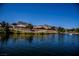 Waterfront homes with landscaping along a pond; mountain views in the background with a clear blue sky at 3116 Richland Dr, Las Vegas, NV 89134