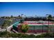 Well-maintained tennis courts with green and red surfaces, complete with fencing, lighting, and seating at 3116 Richland Dr, Las Vegas, NV 89134