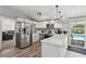 Open kitchen with white cabinets and stainless appliances, connected to the dining area and backyard pool at 3140 Sundown Dr, Las Vegas, NV 89169