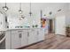 Open kitchen with white cabinets, laminate floors, stainless appliances, and a view into the dining area at 3140 Sundown Dr, Las Vegas, NV 89169