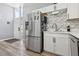 Kitchen featuring stainless steel refrigerator and white cabinets with modern backsplash at 3140 Sundown Dr, Las Vegas, NV 89169