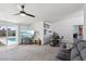 Spacious living room with a stylish bar, modern ceiling fan, and sliding door access to the pool area at 3140 Sundown Dr, Las Vegas, NV 89169