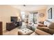 Comfortable living room with a tan couch, green rug, and sliding door to the outside patio at 3151 Soaring Gulls Dr # 1201, Las Vegas, NV 89128