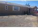 Side exterior shot with tan siding, a small covered porch with chairs, and minimal landscaping at 3451 Ramona Ln, Pahrump, NV 89048