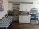 Kitchen with white cabinetry, dark appliances, mosaic backsplash, and plank flooring at 3451 Ramona Ln, Pahrump, NV 89048