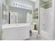 Bathroom with a tub-shower combo, expansive mirror and vanity, with neutral tiling at 3825 Ormond Beach St # 203, Las Vegas, NV 89129