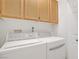 Laundry room with white washer and dryer set, complemented by wood cabinetry at 3825 Ormond Beach St # 203, Las Vegas, NV 89129